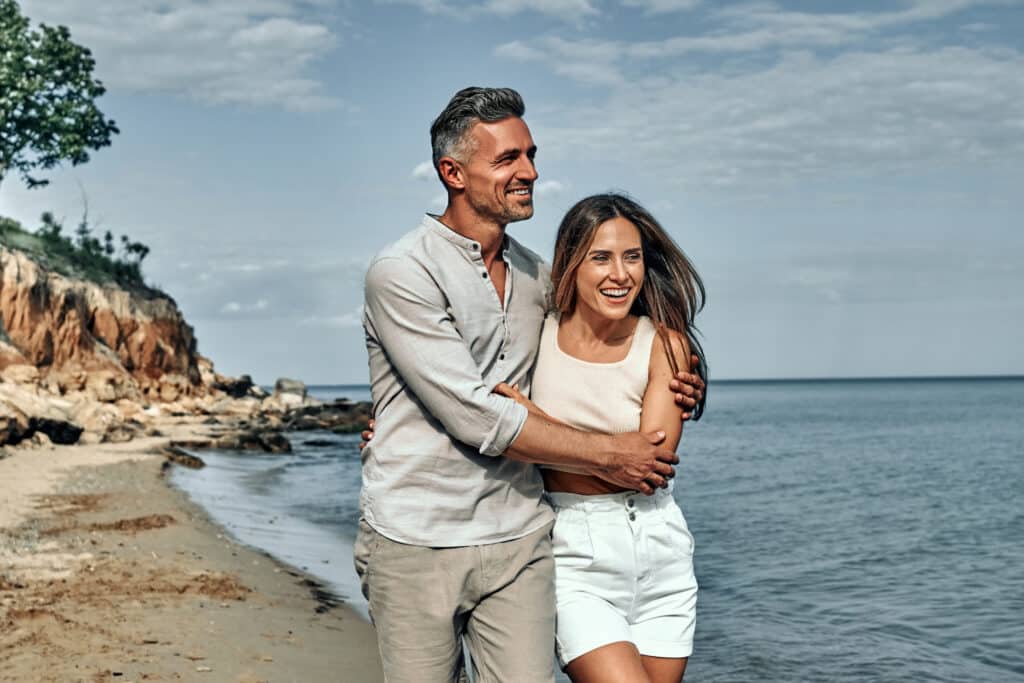 Attractive couple cuddling at the beach.